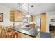 Bright kitchen featuring wood cabinets, a cooktop island, and a breakfast bar area at 6235 E 6Th Avenue Pkwy, Denver, CO 80220