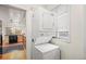 Compact laundry setup with stacked washer and dryer unit, adjacent to kitchen, with natural light through a window at 6235 E 6Th Avenue Pkwy, Denver, CO 80220