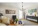 Bright living room with hardwood floors, chandelier and an abundance of natural light from shuttered windows at 6235 E 6Th Avenue Pkwy, Denver, CO 80220