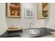 Convenient wet bar with a stainless-steel sink, black countertop, and stylish open shelving at 6235 E 6Th Avenue Pkwy, Denver, CO 80220