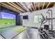 Finished basement featuring gym equipment, projector, screen and golf simulator at 9751 Mobile St, Commerce City, CO 80022