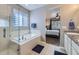 Bright bathroom featuring a soaking tub with shower and granite countertop sink at 9751 Mobile St, Commerce City, CO 80022