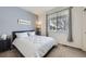 Cozy bedroom featuring a full-sized bed and large window with tree views at 9751 Mobile St, Commerce City, CO 80022