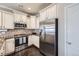 Bright kitchen with stainless steel appliances, white cabinets and a mosaic backsplash at 9751 Mobile St, Commerce City, CO 80022