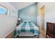 Bright bedroom featuring a blue accent wall, a cozy bed, and natural light from the windows at 1845 Kendall St # 325D, Denver, CO 80214