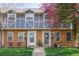 Charming townhome with brick facade, blue siding, well-maintained lawn, and a lovely tree at 12920 W 24Th Pl, Golden, CO 80401