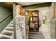Hallway with stairs, refrigerator, storage shelves and a view of the laundry at 12920 W 24Th Pl, Golden, CO 80401