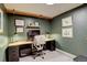 Contemporary home office with built-in desk, dark green walls and track lighting at 12920 W 24Th Pl, Golden, CO 80401