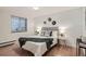 Cozy bedroom with neutral decor, window, and hardwood floors at 155 S Pennsylvania St # 101, Denver, CO 80209