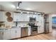 Renovated kitchen featuring white cabinets, quartz counters, and stainless steel appliances at 155 S Pennsylvania St # 101, Denver, CO 80209