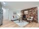 Bright living room featuring a brick fireplace, modern decor, and wood-look floors at 155 S Pennsylvania St # 101, Denver, CO 80209