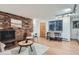 Inviting living area with brick accent wall, fireplace, and modern furnishings at 155 S Pennsylvania St # 101, Denver, CO 80209