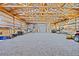 Spacious barn interior with gravel floor, exposed beams and various equipment at 26271 Richmond Hill Rd, Conifer, CO 80433