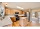 Open kitchen with stainless steel appliances, light wood cabinets, a center island, and hardwood floors at 3532 Morning Glory Dr, Castle Rock, CO 80109
