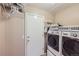 Functional laundry room with modern washer and dryer, and ample storage shelves at 3532 Morning Glory Dr, Castle Rock, CO 80109