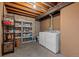 Functional laundry room space with washer, dryer, storage shelves, and wood paneling at 272 S 22Nd Ave, Brighton, CO 80601