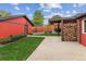Landscaped backyard with a red shed, lawn, wood storage, patio, and partial fence at 4710 W 32Nd Ave, Denver, CO 80212