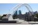 Modern pedestrian bridge with steel arches and a view of downtown buildings at 4710 W 32Nd Ave, Denver, CO 80212
