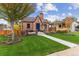 Charming brick home featuring mature trees, a manicured lawn, and a welcoming entrance at 4710 W 32Nd Ave, Denver, CO 80212