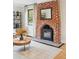 A close up shot of the fireplace in the living room with wood floors and a round table at 4710 W 32Nd Ave, Denver, CO 80212