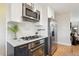 This kitchen features stainless steel appliances, white upper cabinets and gray lower cabinets with a marble countertop at 4710 W 32Nd Ave, Denver, CO 80212
