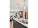 Kitchen island featuring bar seating and a double sink with a fireplace and Gathering room in the background at 4710 W 32Nd Ave, Denver, CO 80212
