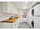 Laundry room with stainless steel washer/dryer, wooden countertop, white cabinetry and view to the exterior at 4710 W 32Nd Ave, Denver, CO 80212
