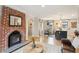 Open concept living room, dining room, and kitchen showcasing the wood floors and brick fireplace at 4710 W 32Nd Ave, Denver, CO 80212