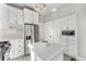 Modern white kitchen featuring stainless steel appliances, a center island, and ample cabinet space at 568 Galapago St, Denver, CO 80204