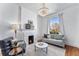 Bright living room featuring hardwood floors, a fireplace, a chandelier, and a comfortable gray couch at 568 Galapago St, Denver, CO 80204