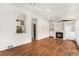 Bright living room with hardwood floors, a cozy fireplace, and open access to the kitchen at 568 Galapago St, Denver, CO 80204