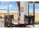 Sunlit dining area with a wooden table, comfortable chairs, and expansive windows with scenic views at 14805 Quince Way, Thornton, CO 80602