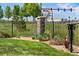 Charming front yard featuring a black metal fence, stone pillar, garden bed, and well-maintained lawn at 14805 Quince Way, Thornton, CO 80602