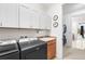 Bright laundry room with modern washer and dryer, ample cabinet storage, and convenient utility sink at 14805 Quince Way, Thornton, CO 80602