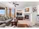 Bright living room features a cozy fireplace, ceiling fan, and large windows showcasing the beautiful mountain views at 14805 Quince Way, Thornton, CO 80602