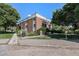 A well-maintained red brick apartment building with mature landscaping and parking at 5995 W Hampden Ave # 18C, Denver, CO 80227