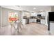Modern kitchen with stainless steel appliances, white cabinets, and an adjacent dining area at 10049 Granby Dr, Commerce City, CO 80022