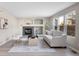 Inviting living room with a fireplace, neutral paint, a modern sofa, and natural light at 10049 Granby Dr, Commerce City, CO 80022