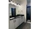 Modern bathroom with dual sink vanity with black countertops and hardware with glass enclosed shower at 14295 Currant St, Broomfield, CO 80020