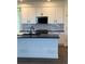 Modern kitchen features white cabinets, black hardware, black countertops and backsplash with black appliances at 14295 Currant St, Broomfield, CO 80020