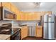 Efficient kitchen features stainless steel appliances and light wood cabinets at 8653 E Dry Creek Rd # 1114, Englewood, CO 80112
