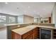 Basement wetbar with granite countertop, sink, wine cooler and cabinetry at 13087 W 27Th Ln, Golden, CO 80401