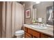 Cozy bathroom featuring cherrywood vanity, granite countertop, neutral shower curtain, and framed art print at 13087 W 27Th Ln, Golden, CO 80401