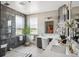Bathroom featuring dual sinks, stylish vanities, modern lighting fixtures, walk in shower and large potted plant at 13087 W 27Th Ln, Golden, CO 80401