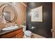 Stylish powder room featuring custom wall texture, decorative art, and wooden cabinet with granite countertop at 13087 W 27Th Ln, Golden, CO 80401