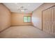 Spacious carpeted bedroom featuring ceiling fan, neutral walls, base trim, large closet and window for natural light at 13087 W 27Th Ln, Golden, CO 80401