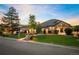 Beautiful brick home with a manicured lawn, mature trees, and a welcoming front porch at 13087 W 27Th Ln, Golden, CO 80401