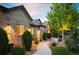 Attractive brick home with lush landscaping, a curved walkway, and tasteful outdoor lighting at 13087 W 27Th Ln, Golden, CO 80401