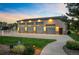 Spacious four-car garage with elegant lighting and lush landscaping at dusk at 13087 W 27Th Ln, Golden, CO 80401