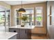 Island in a kitchen with white countertop and gray cabinetry with window views of outdoor patio and grill at 13087 W 27Th Ln, Golden, CO 80401